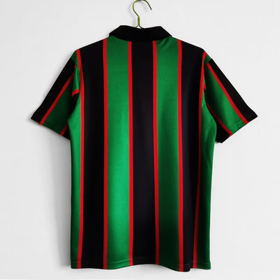 a green and black striped shirt hanging on a wall