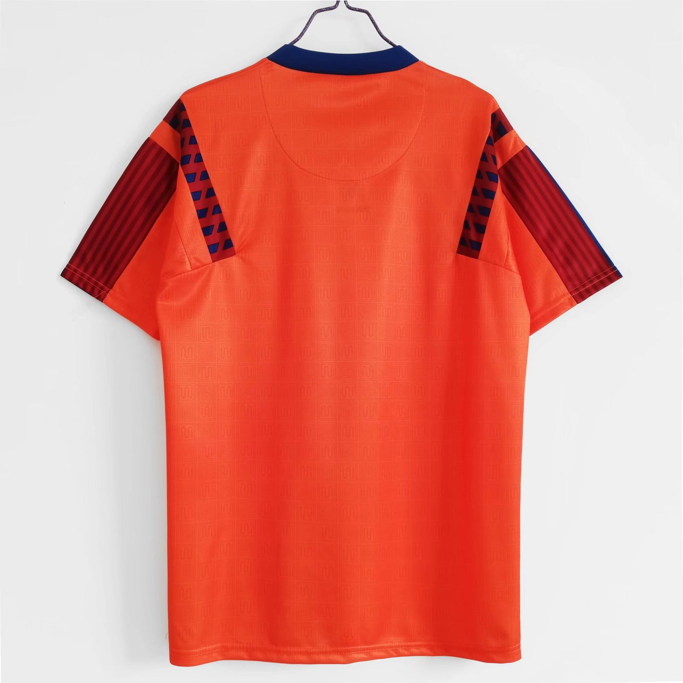 an orange t - shirt hanging on a hanger