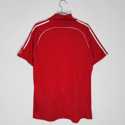 a red shirt hanging on a white wall