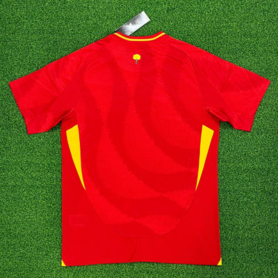 a red and yellow soccer jersey laying on a green field