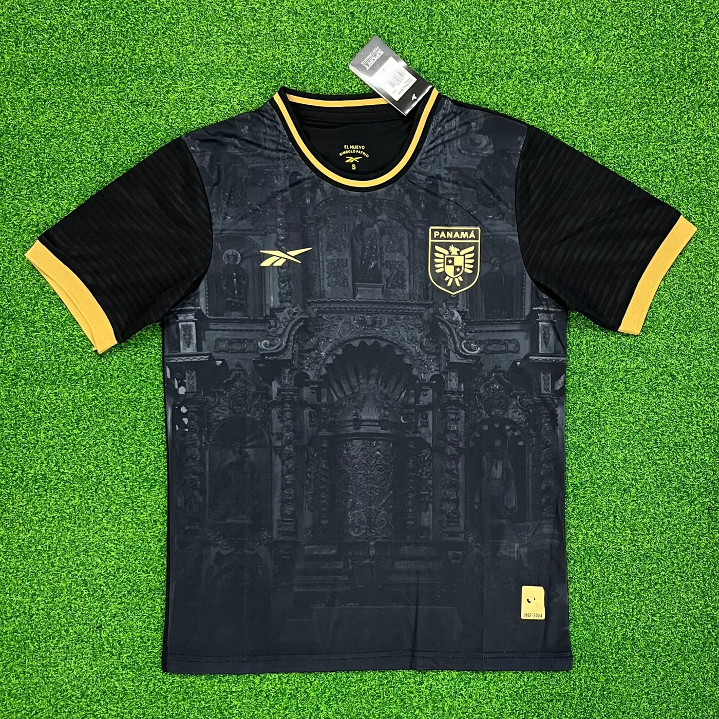 a black and yellow soccer jersey sitting on top of a green field