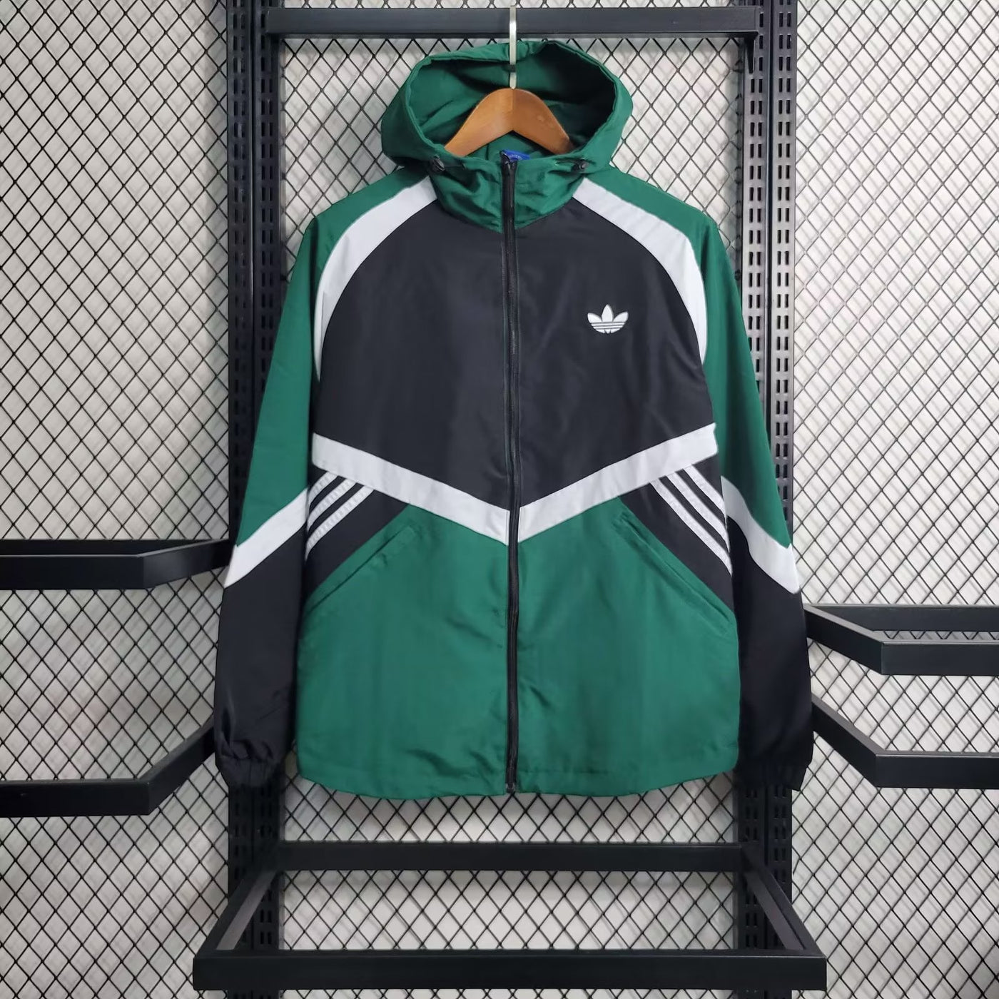 a green adidas jacket hanging on a rack