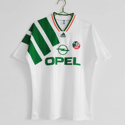 a green and white shirt hanging on a hanger