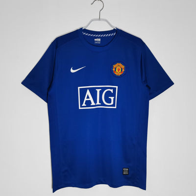 a blue manchester united shirt hanging on a hanger