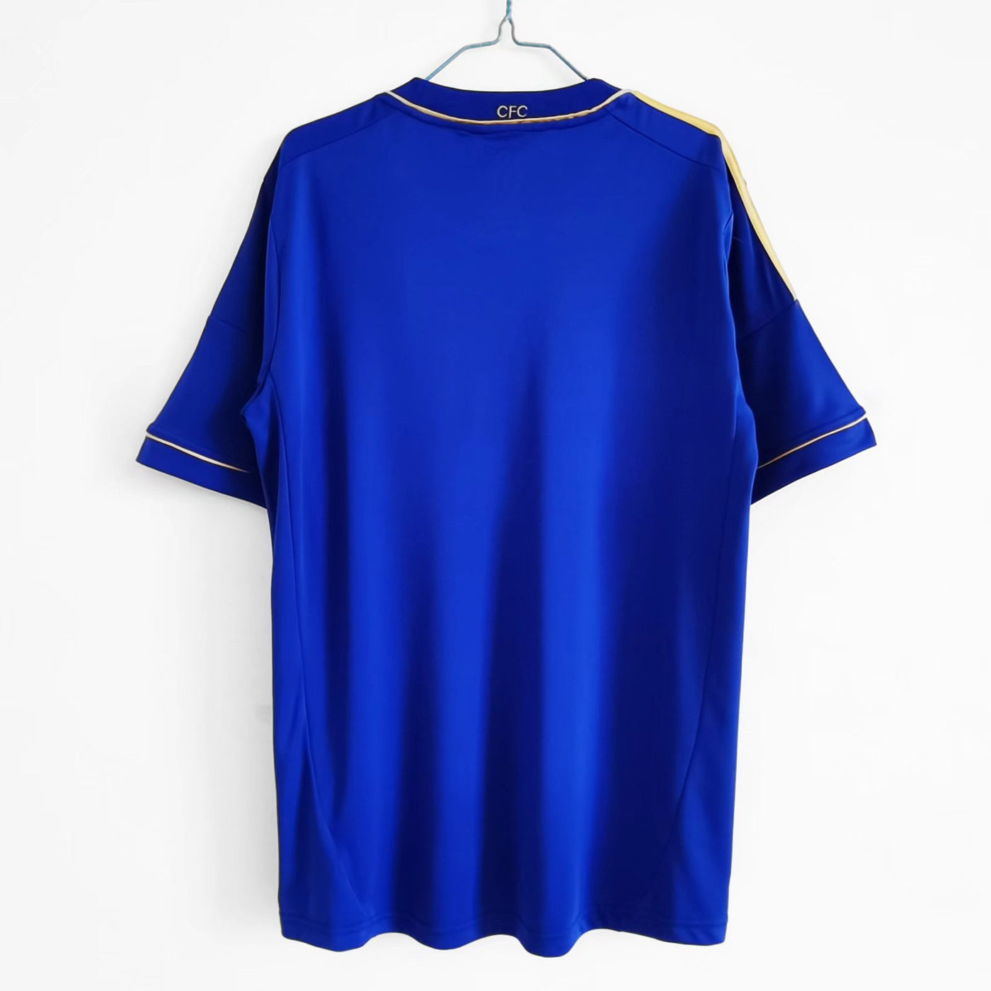 a blue t - shirt hanging on a white wall