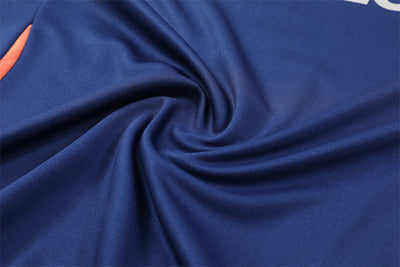 a close up view of a blue fabric with orange stitching