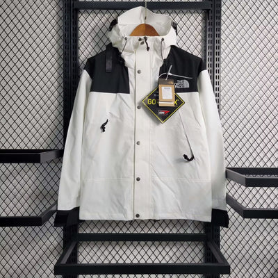 a white and black jacket hanging on a rack