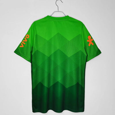 a green t - shirt with orange letters on it