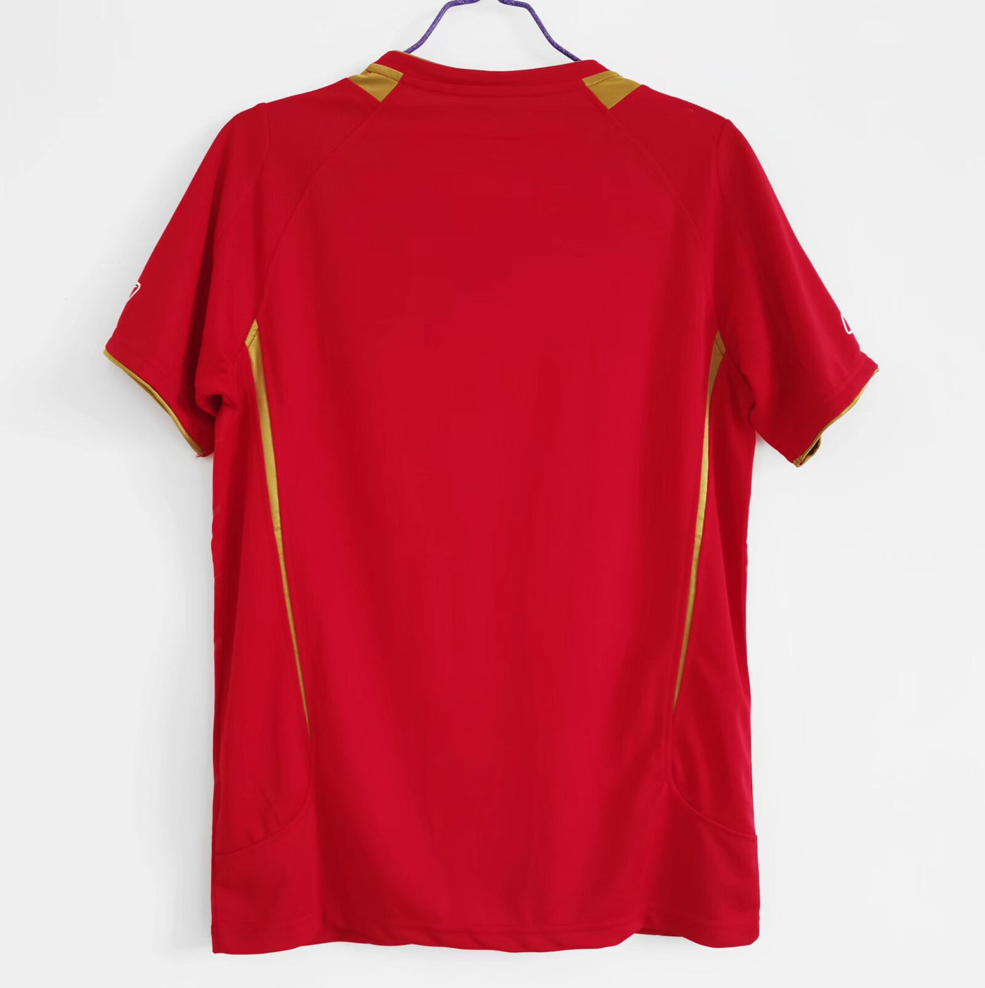 a red shirt hanging on a white wall