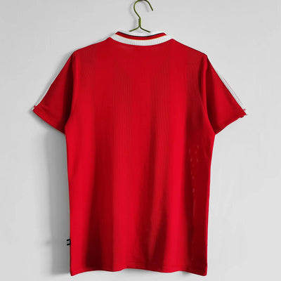 a red shirt hanging on a white wall