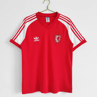 a red adidas shirt hanging on a wall