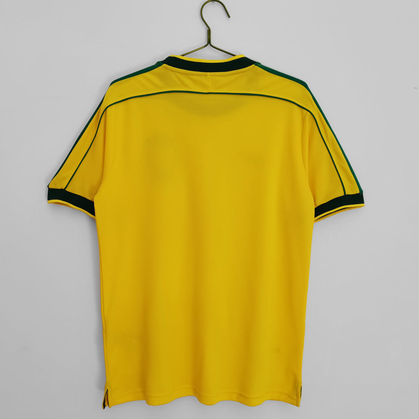 a yellow soccer jersey hanging on a hanger