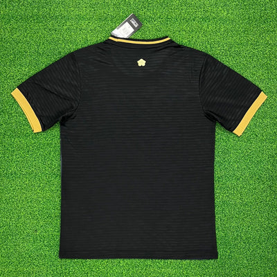 a black and yellow shirt laying on top of a green field