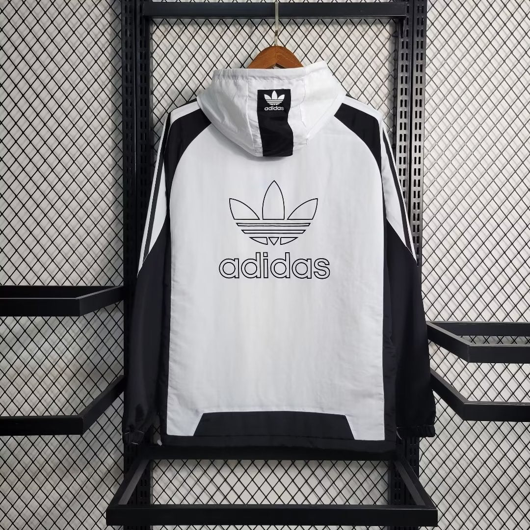 a white and black adidas jacket hanging on a rack