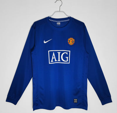 a blue manchester united shirt hanging on a hanger