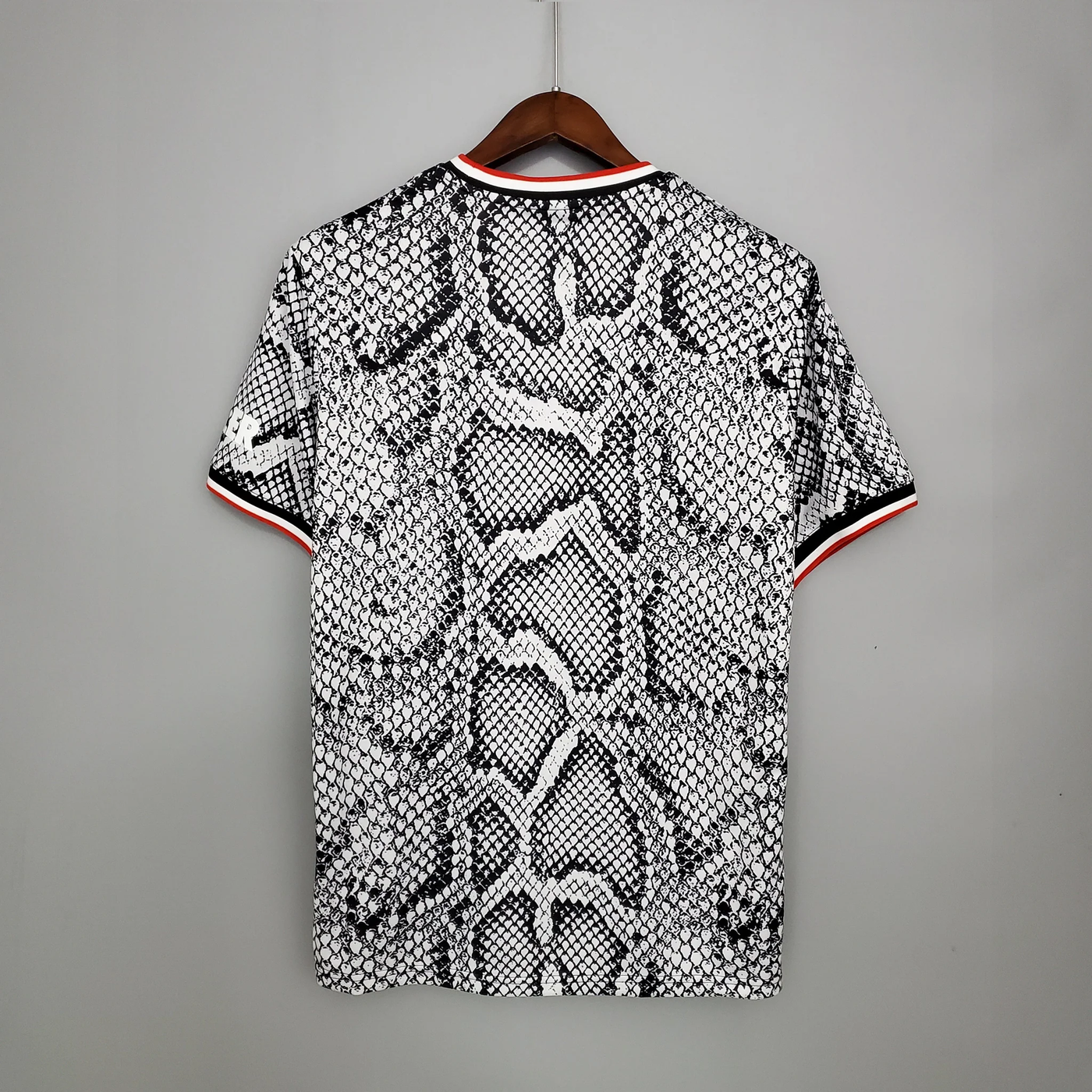 a black and white snake skin polo shirt hanging on a hanger