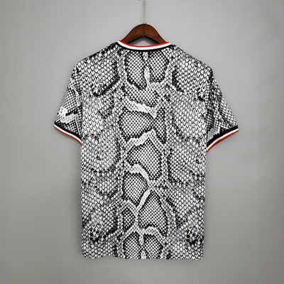 a black and white snake skin polo shirt hanging on a hanger