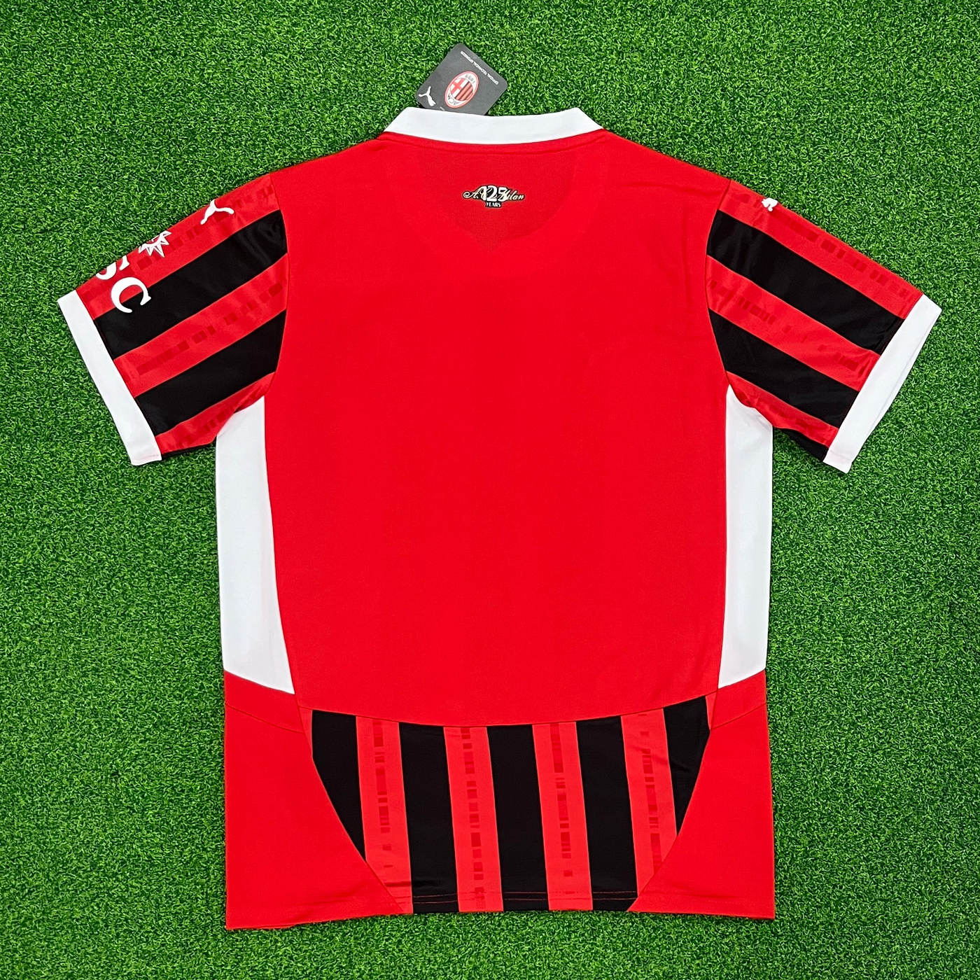 a red and black soccer jersey laying on a green field