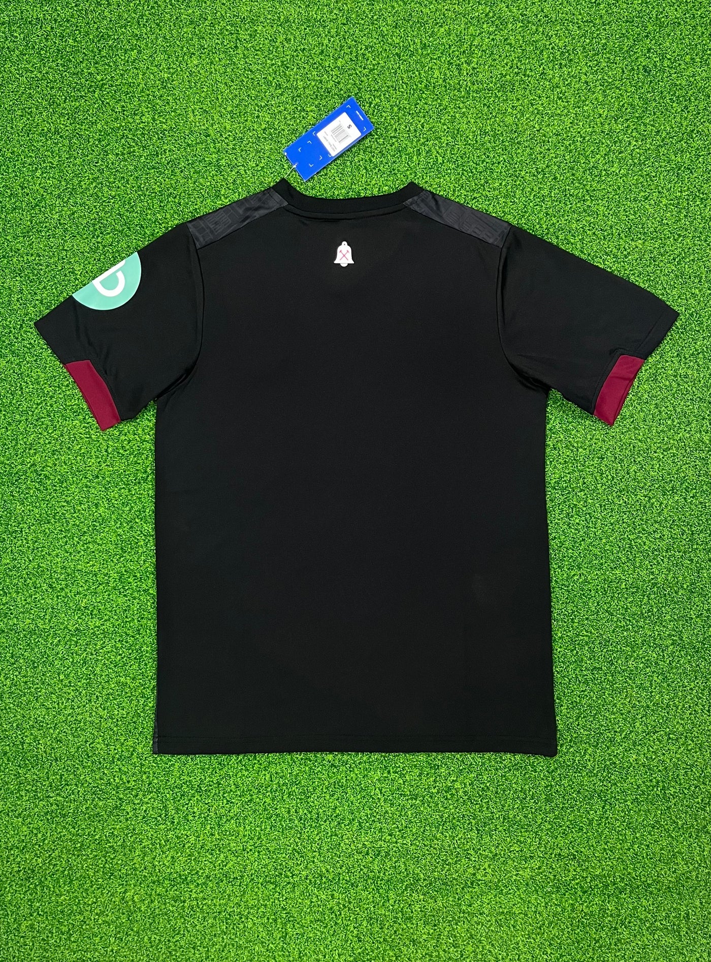 a t - shirt laying on top of a green field