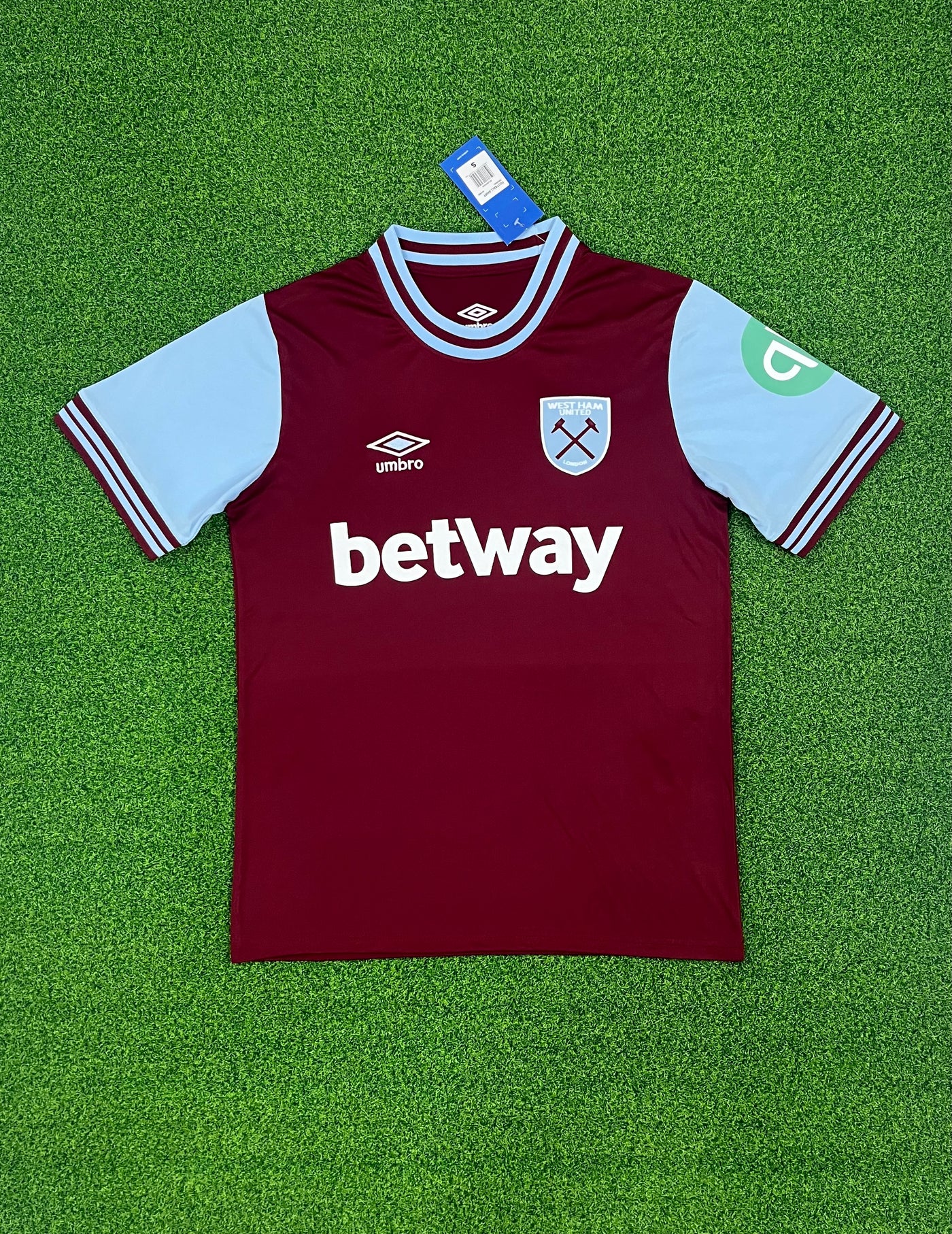 a maroon and blue soccer jersey laying on a green field