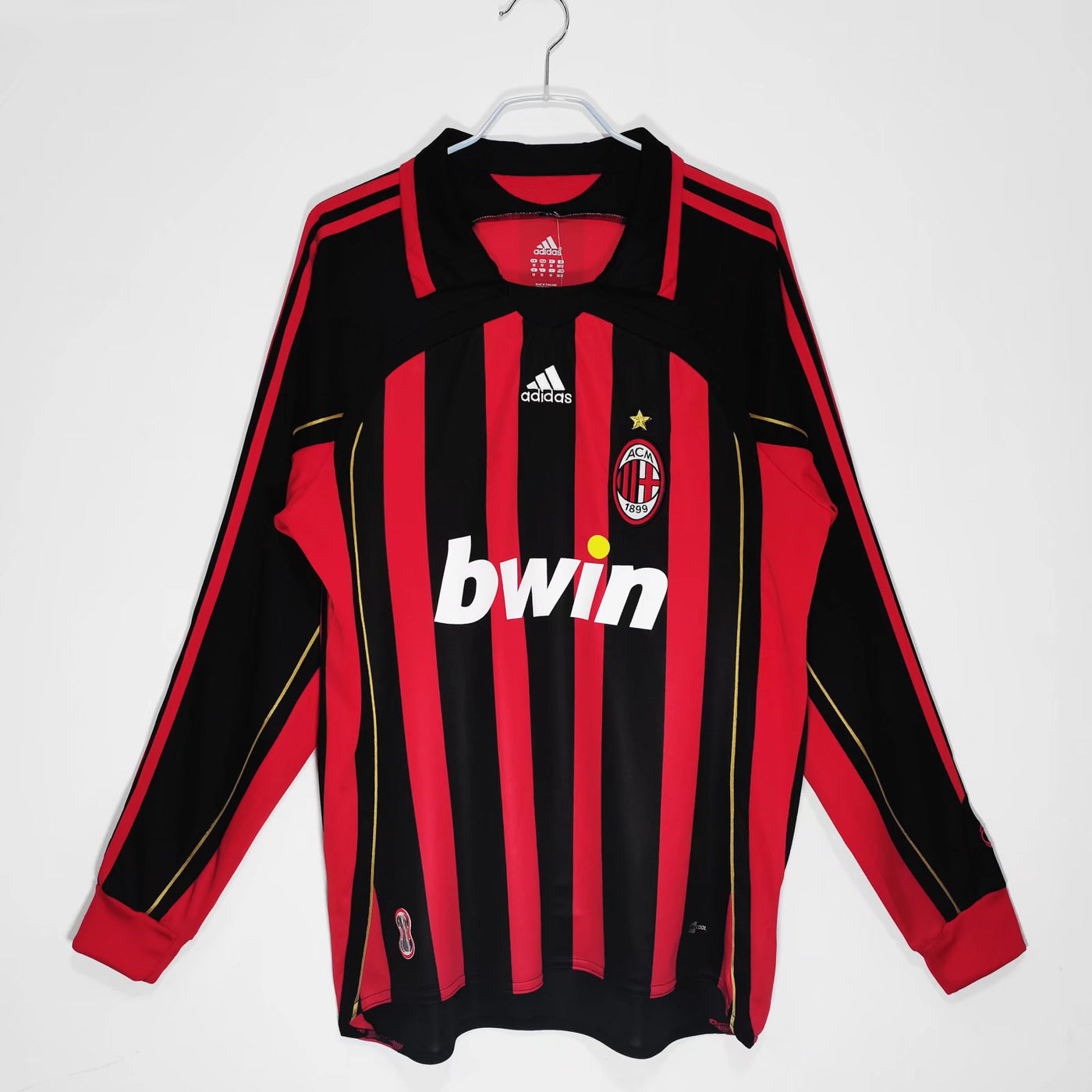 a red and black soccer jersey hanging on a hanger