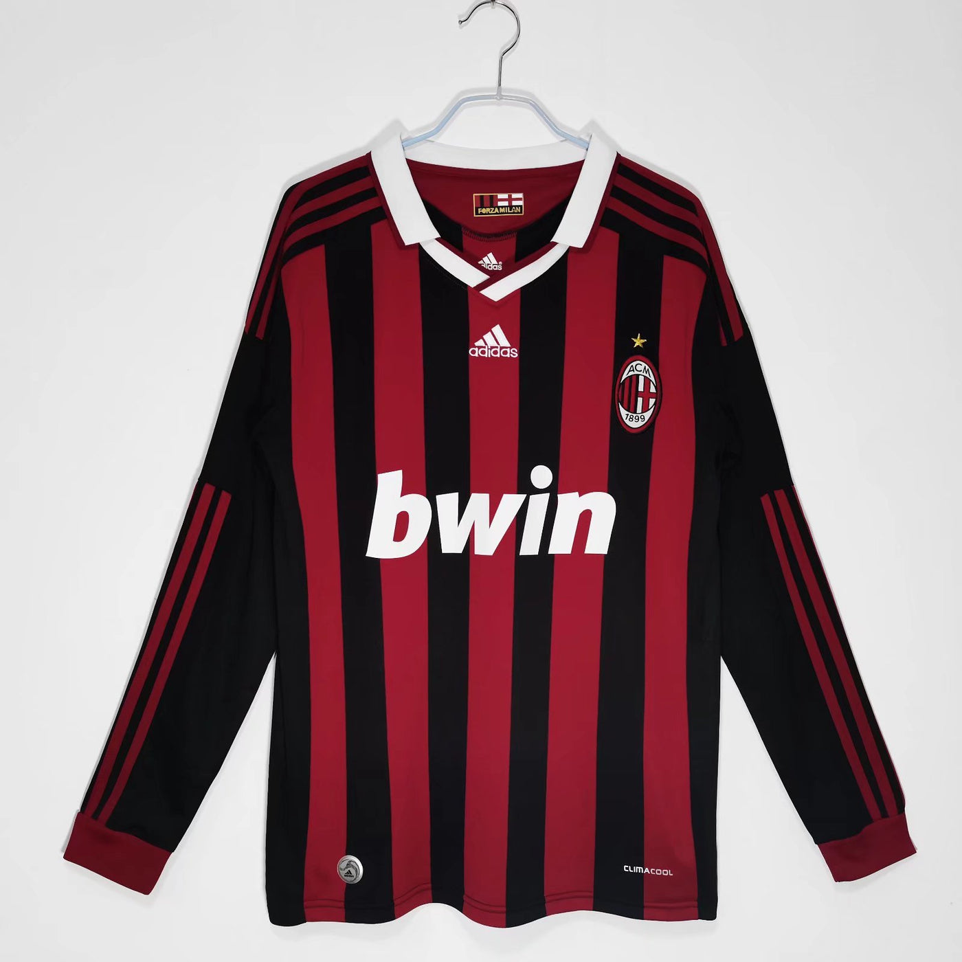 a red and black soccer jersey hanging on a hanger