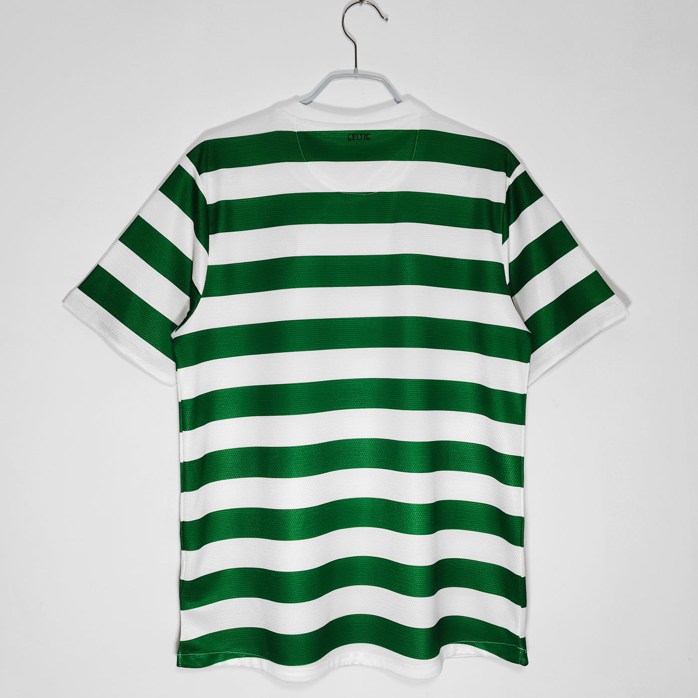 a green and white striped shirt hanging on a hanger