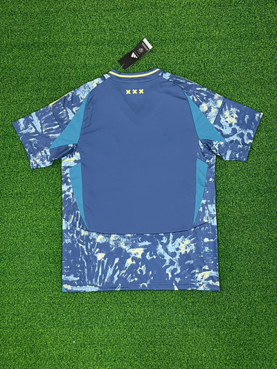 a blue and white shirt sitting on top of a green field