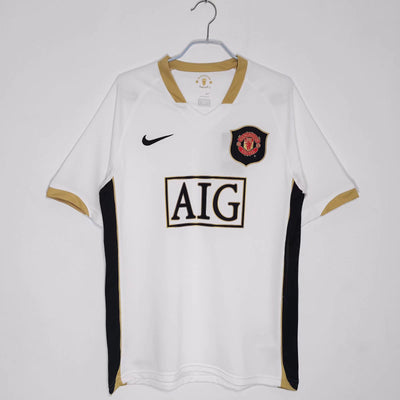 a white shirt with a black and gold patch on it