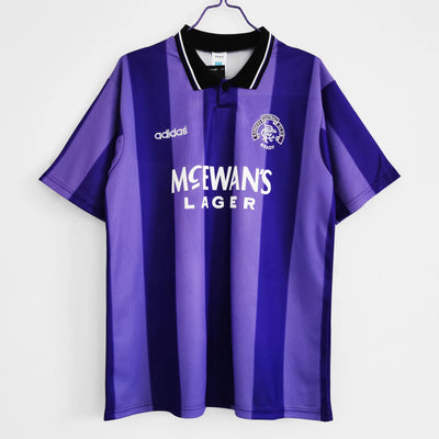 a purple and black soccer jersey hanging on a hanger