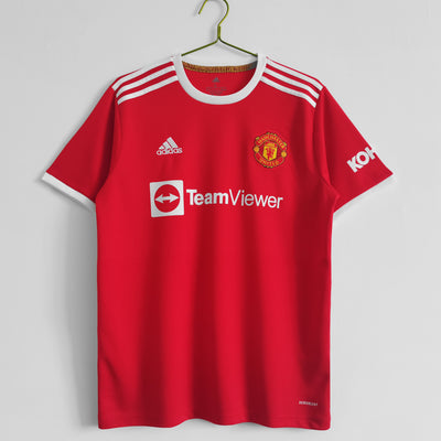 a red manchester united shirt hanging on a hanger