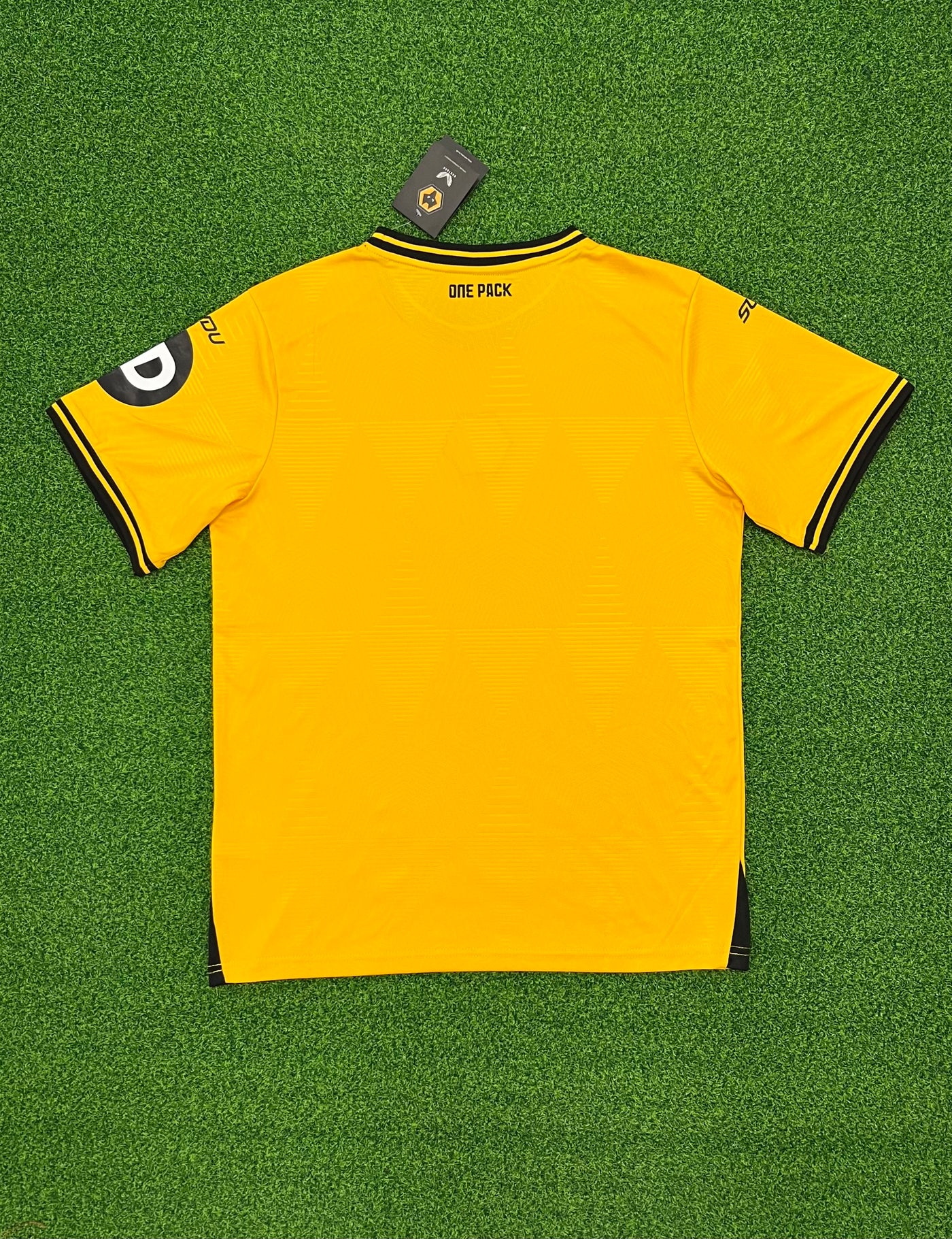 a yellow soccer jersey laying on a green field