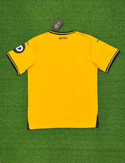 a yellow soccer jersey laying on a green field