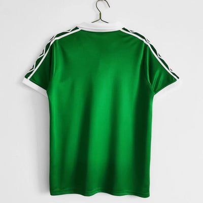 a green t - shirt hanging on a hanger