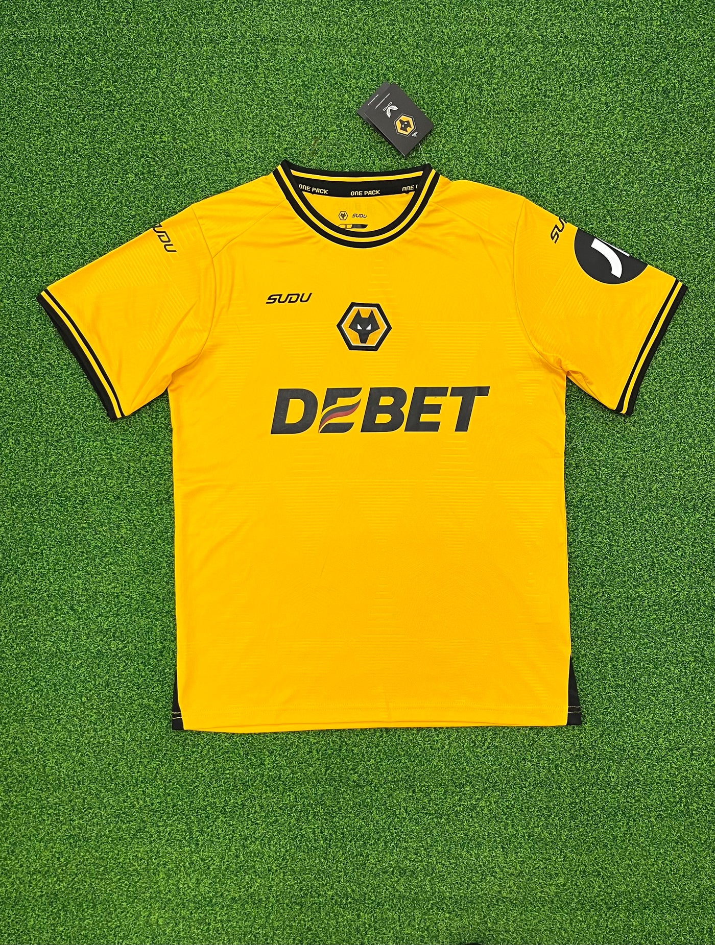 a yellow soccer jersey laying on a green field