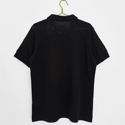 a black shirt hanging on a white wall