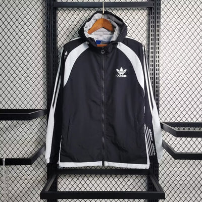 a black and white adidas jacket hanging on a rack