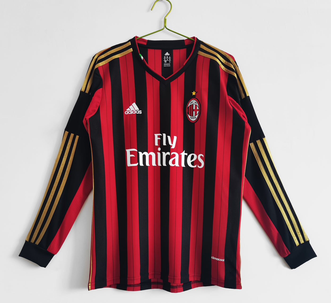 a red and black soccer jersey hanging on a hanger