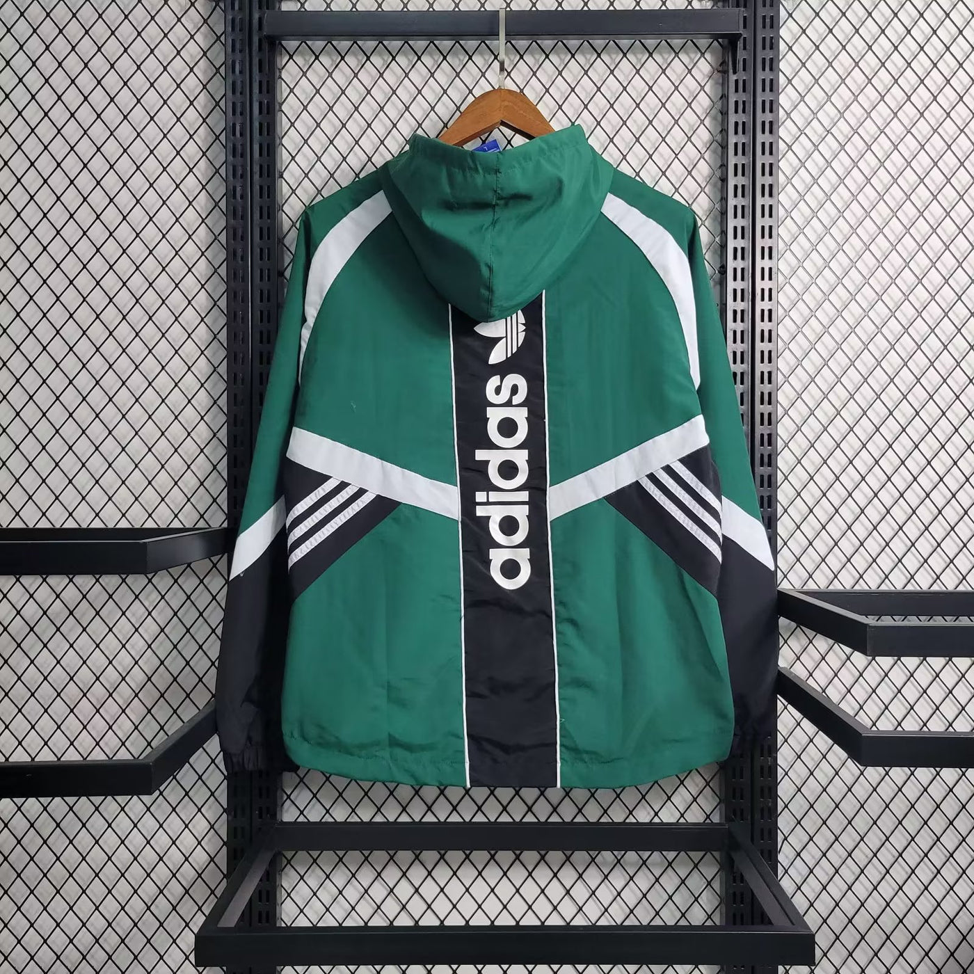 a green adidas jacket hanging on a rack