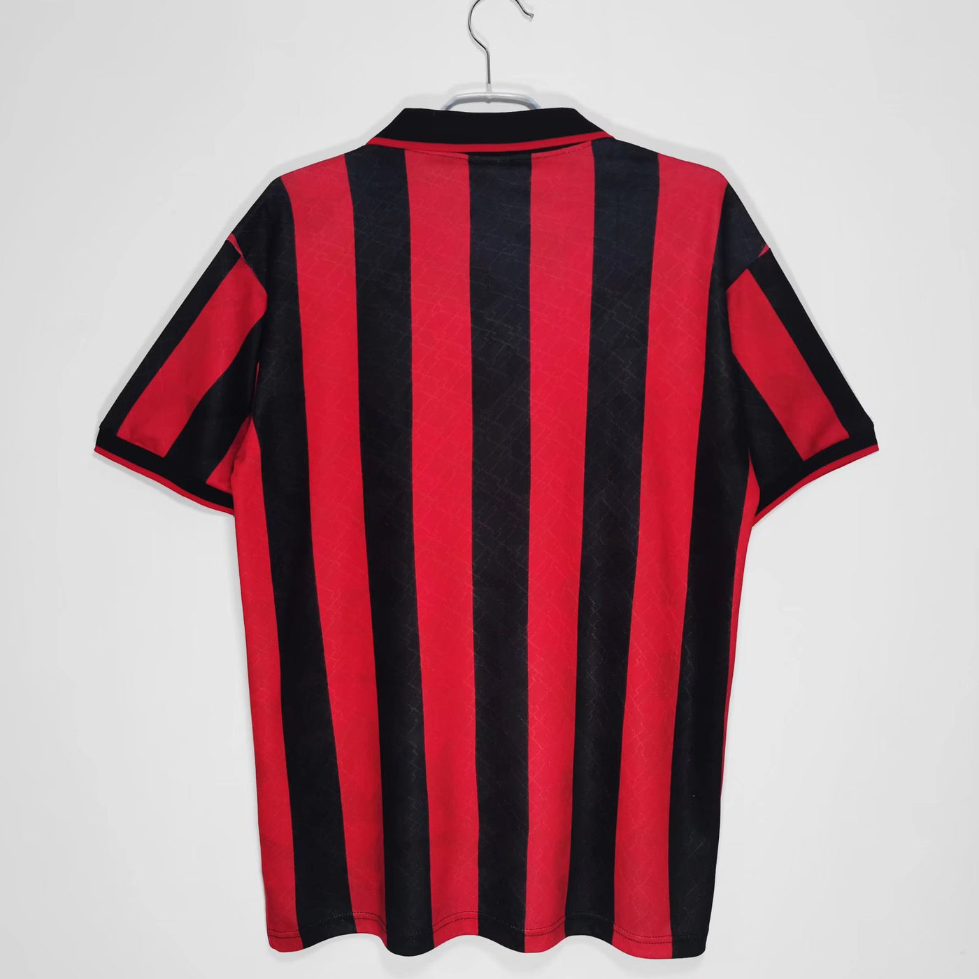 a red and black striped shirt hanging on a hanger