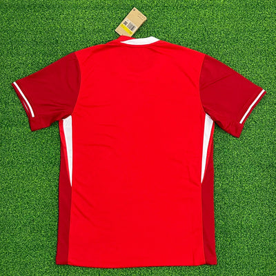 a red shirt laying on top of a green field