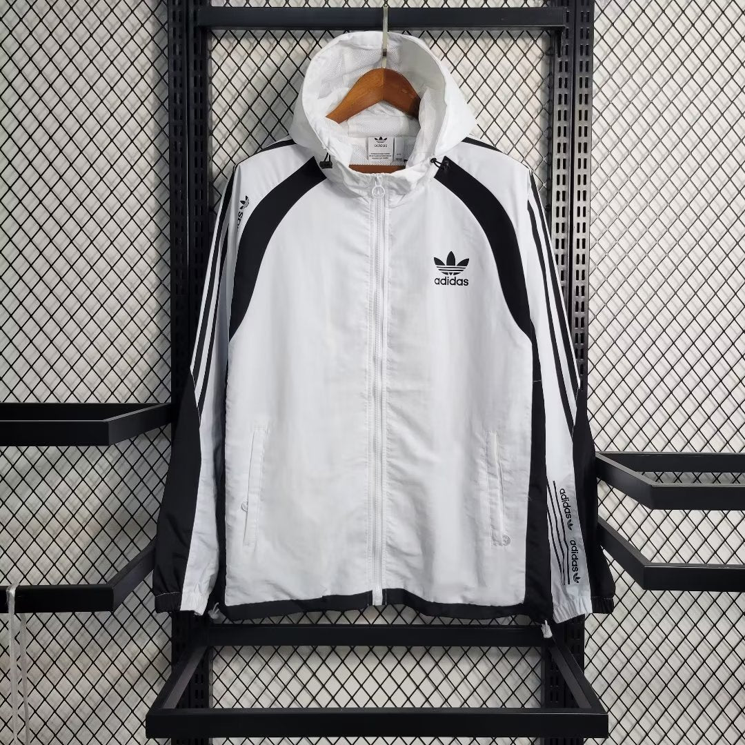 a white adidas jacket hanging on a rack