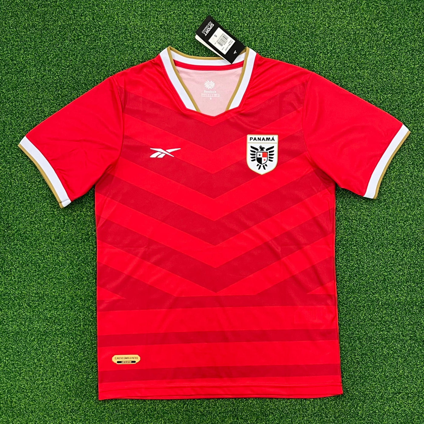 a red soccer jersey laying on a green field