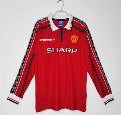 a red manchester united shirt hanging on a hanger