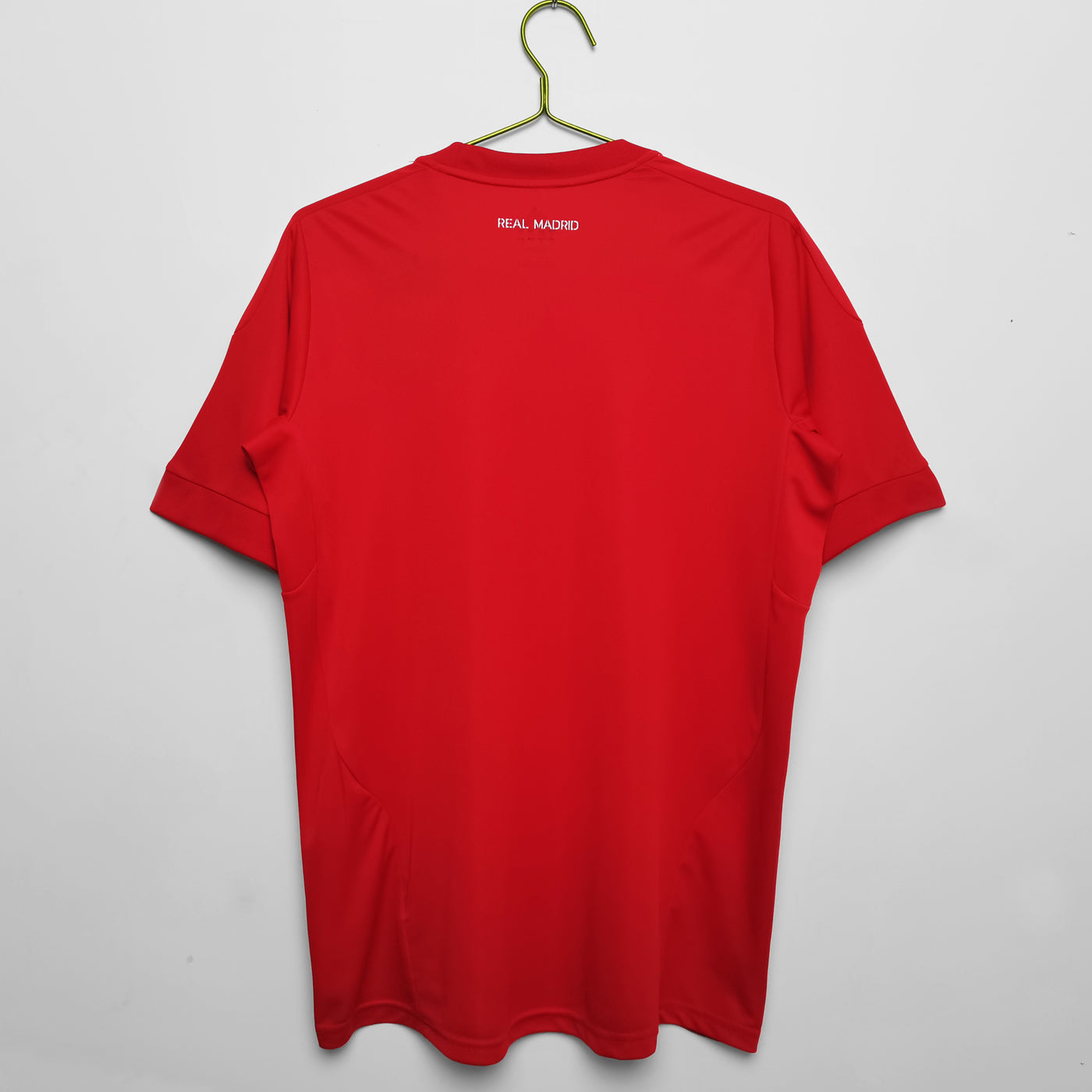 a red t - shirt hanging on a hanger