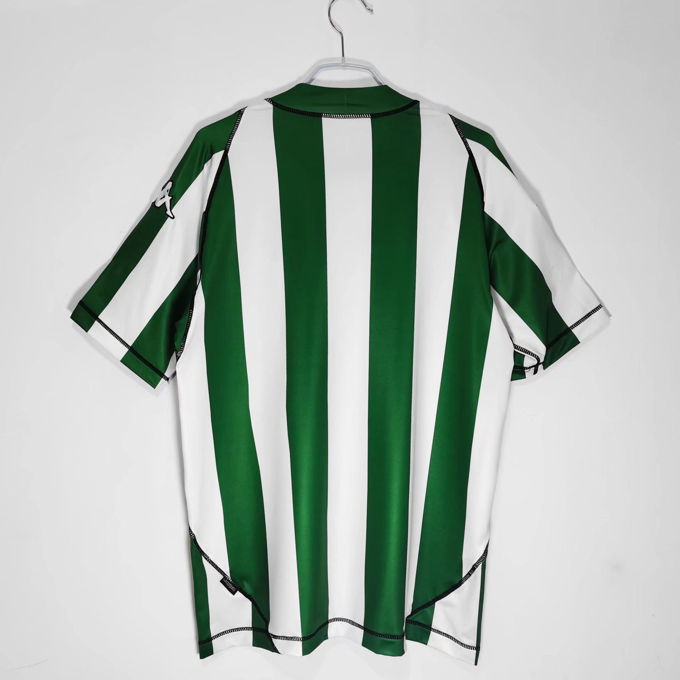 a green and white striped shirt hanging on a hanger