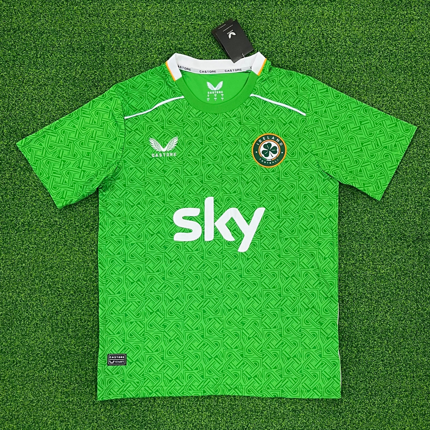 a green soccer jersey sitting on top of a green field