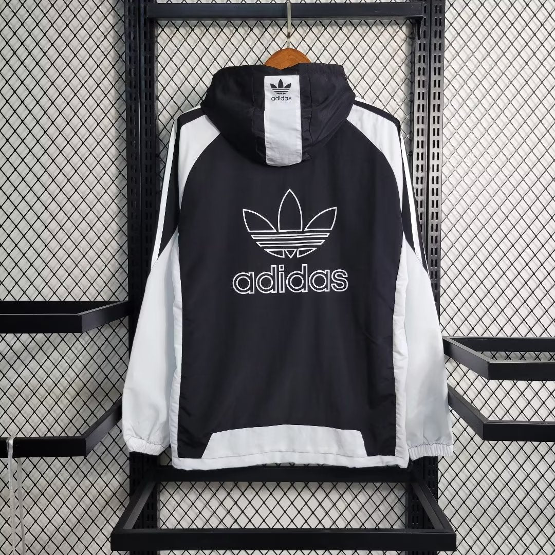 a black and white adidas jacket hanging on a rack