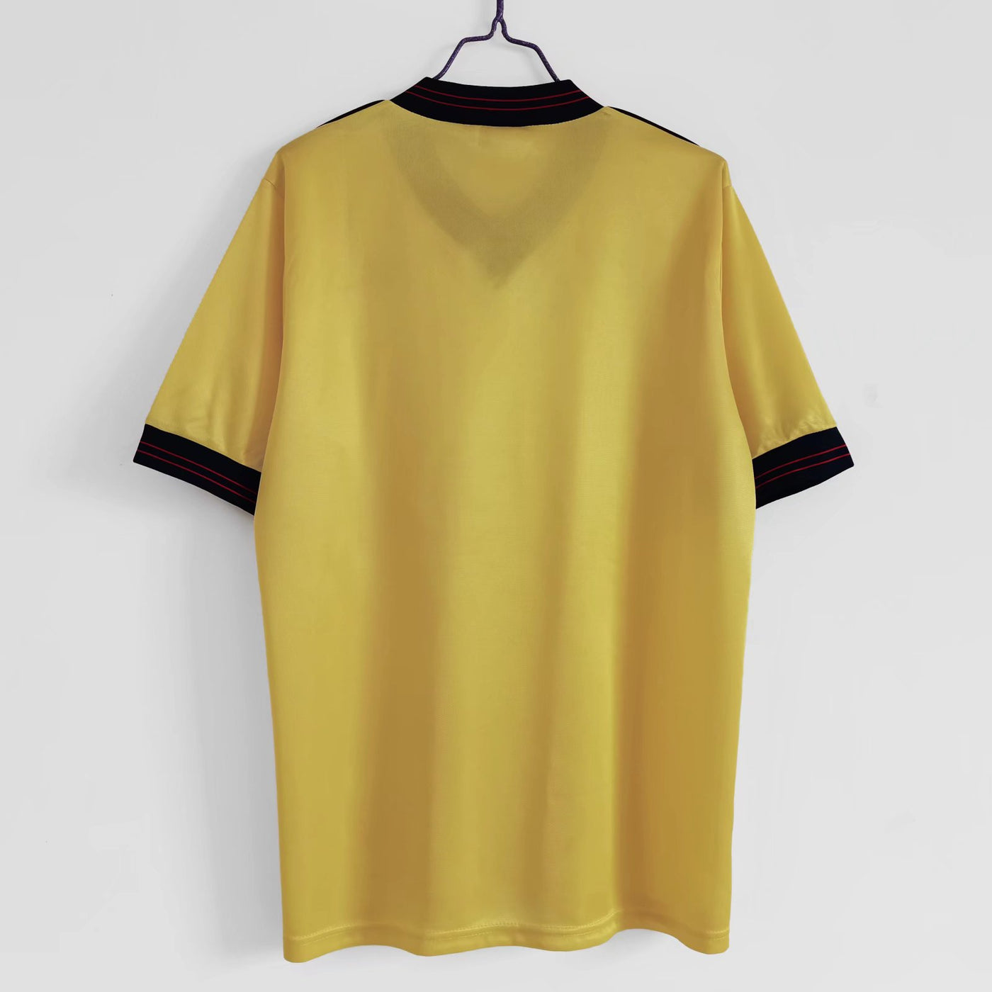 a yellow t - shirt hanging on a hanger