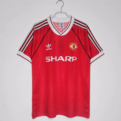 a red manchester united shirt hanging on a hanger